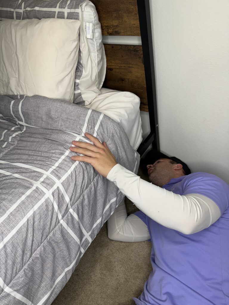 Bed Bugs a pest control technician inspecting under a bed for signs of a bed bug infestation